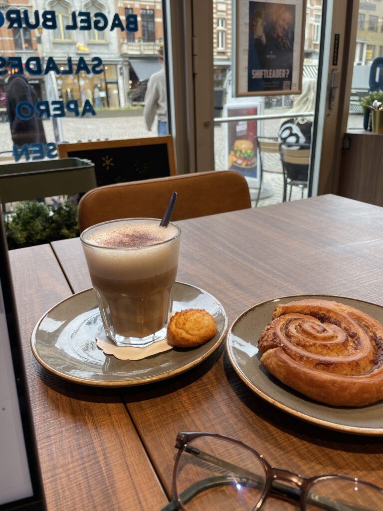 Chai latte en cinnamon roll in café